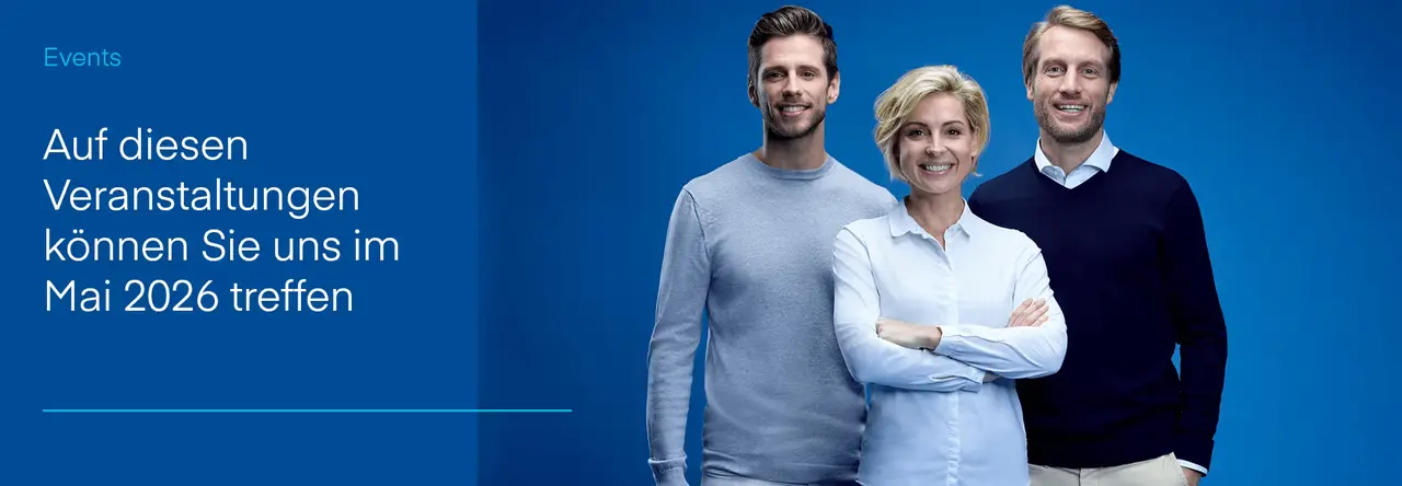 Drei lächelnde Personen eines Teams vor blauem Hintergrund