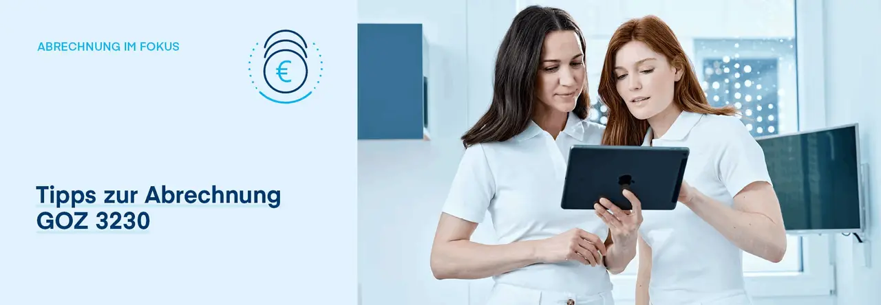 Zwei Zahnarzthelferinnen schauen gemeinsam auf ein Tablet in der Praxis.