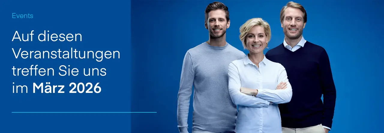 Drei lächelnde Personen eines Teams vor blauem Hintergrund.