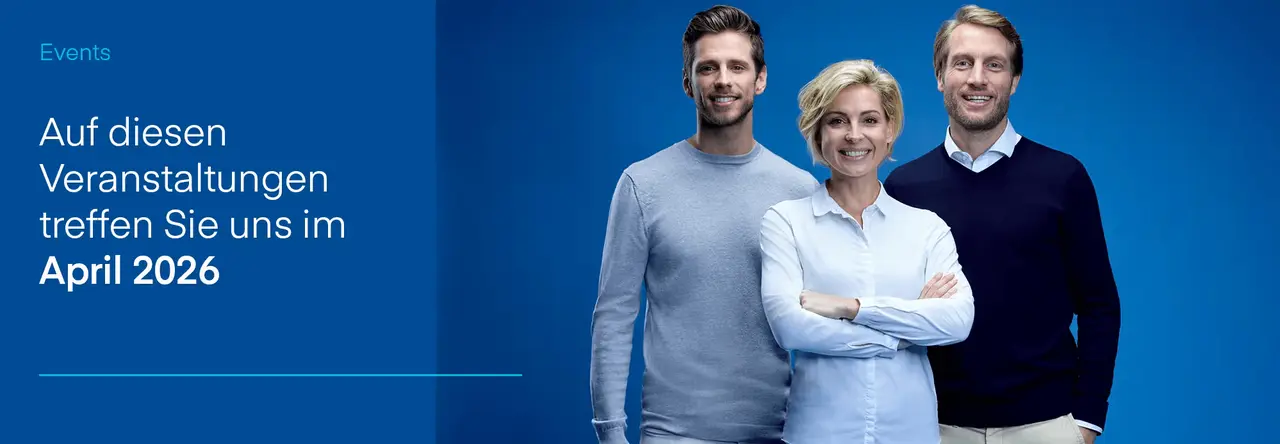 Drei lächelnde Personen eines Teams vor blauem Hintergrund.