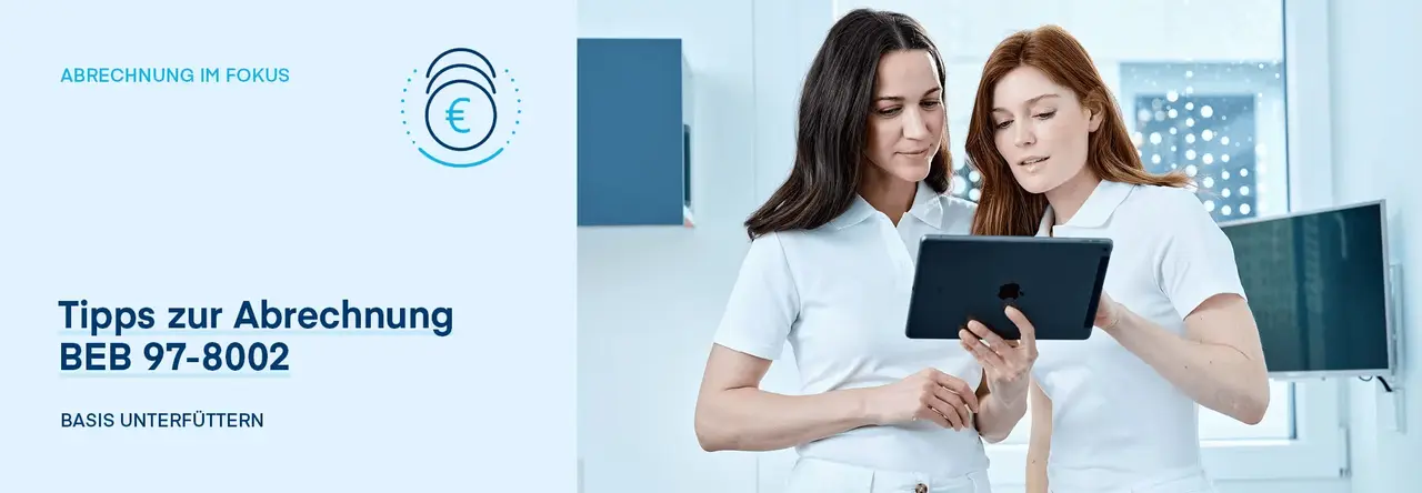 Zwei Zahnarzthelferinnen schauen gemeinsam auf ein Tablet in der Praxis.