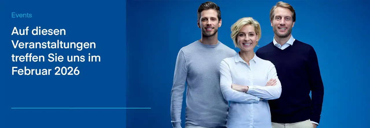 Drei lächelnde Personen eines Teams vor blauem Hintergrund.