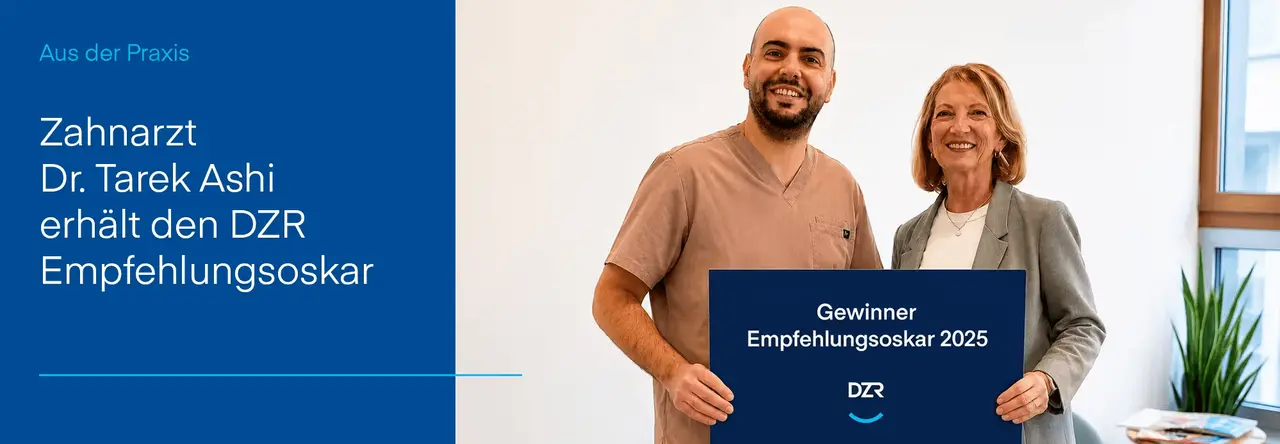 Zahnarzt und DZR-Mitarbeiterin halten gemeinsam Schild mit Aufschrift „Gewinner Empfehlungsoskar 2025"