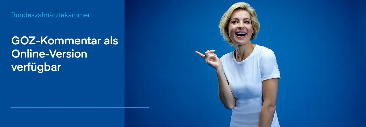 Eine Frau mit blondem Haar und weißem T-Shirt steht vor einem blauen Hintergrund und lächelt herzlich, während sie nach links zeigt. Links im Bild steht auf einem blauen Hintergrund der Text: 'GOZ-Kommentar als Online-Version verfügbar'