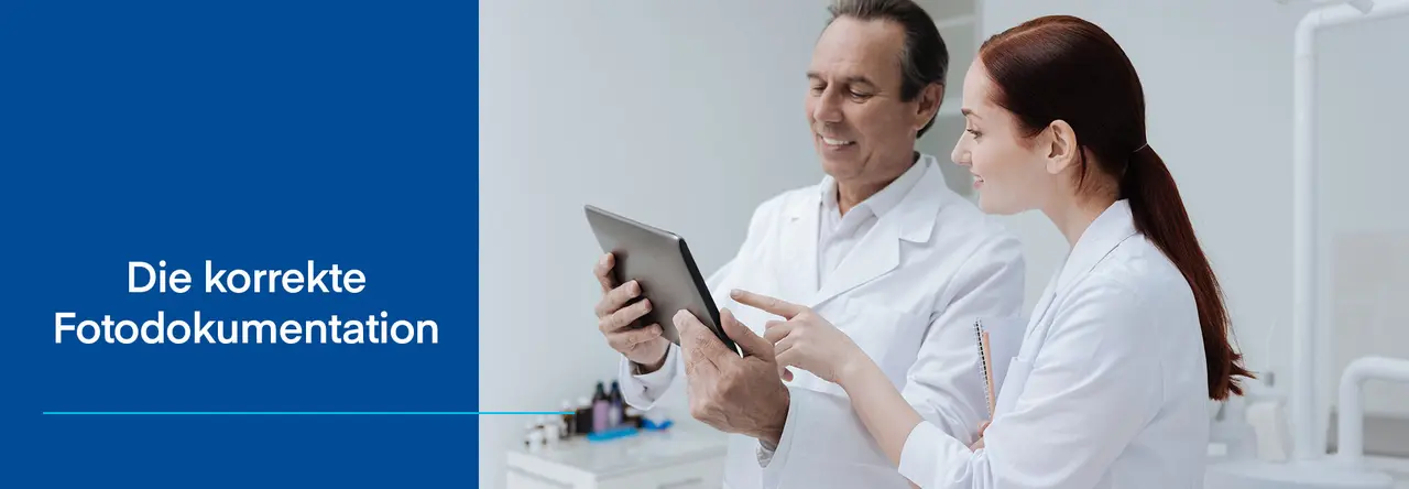 Zahnarzt und Zahnärztin schauen auf Tablet